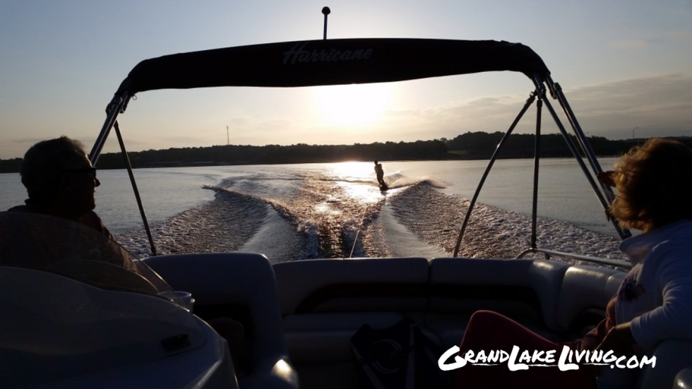 Boat moving across Grand Lake at sunrise.